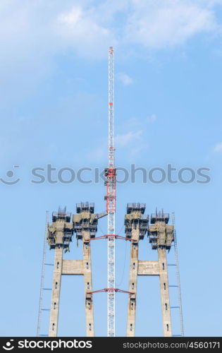 the construction of a bridge across the river with the supports, structural elements, cranes