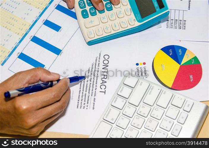 The contract documents and calculator at desk.