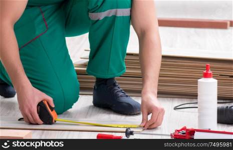 The contractor working on laminate wooden floor. Contractor working on laminate wooden floor