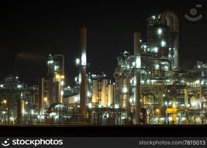 The converters, pipes, tubes chimneys and structures of a illuminated petrochemical plant at night