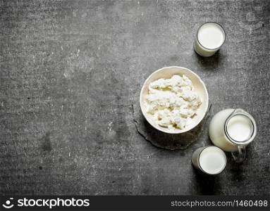 The cottage cheese in a bowl and milk. On the stone table.. The cottage cheese in a bowl and milk.