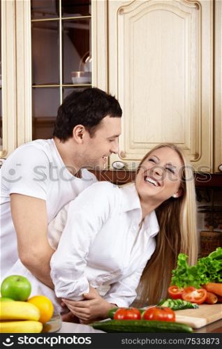 The couple embraces and laughs and kitchen