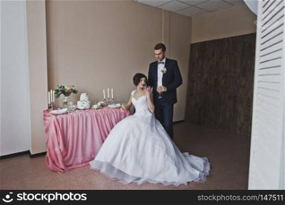 The couple in beautiful outfits sitting at the beautiful table.. The bride and groom sit at the Banquet table 6450.