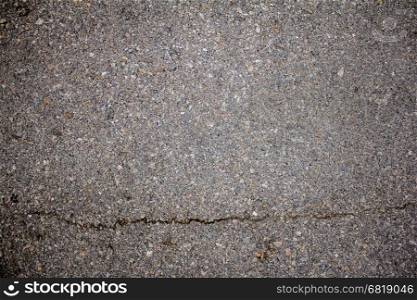 The cracked asphalt road texture for background