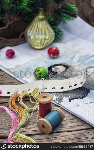 The creation of Christmas decorations.. Spools of thread and beads in Christmas songs in vintage style.