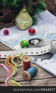 The creation of Christmas decorations.. Spools of thread and beads in Christmas songs in vintage style.