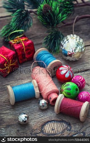 The creation of Christmas decorations.. Spools of thread and beads in Christmas songs in vintage style.