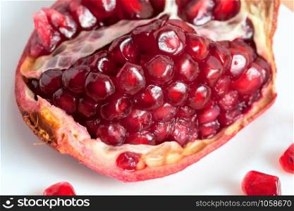 The cut pomegranate and grains on a plate.. The cut pomegranate and grains on a plate