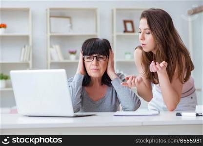 The daughter explaining to mom how to use computer. Daughter explaining to mom how to use computer
