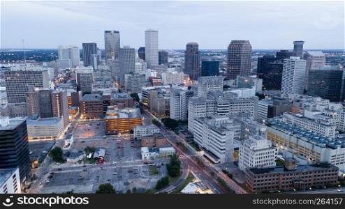The daylight fades as lights inside buildings turn on in an aerial view of New Orleans