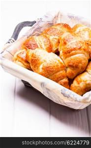 The delicious croissants in a basket for breakfast. The fresh croissants