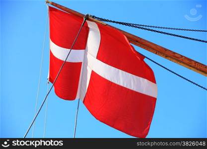 The denmark or danish flag on sailboat with blue sky on background
