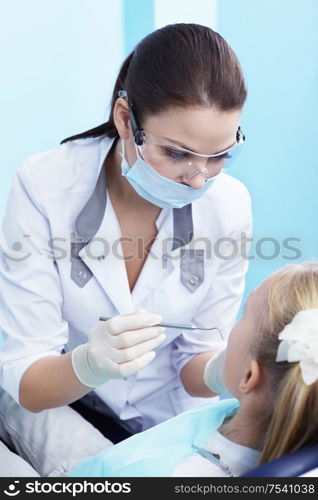 The dentist examines a child in dentistry