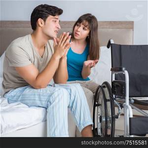 The desperate man on wheelchair with his sad wife. Desperate man on wheelchair with his sad wife