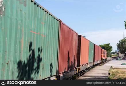 The diesel-electric locomotive is running with the container boxcar to the urban station,Bangkok Thailand.