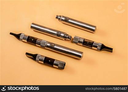 The different parts of an electronic cigarette displayed with three such cigarettes.