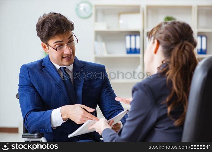 The disabled businessman having discussion with female colleague. Disabled businessman having discussion with female colleague. The disabled businessman having discussion with female colleague