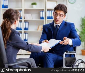 The disabled businessman having discussion with female colleague. Disabled businessman having discussion with female colleague