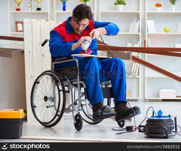 The disabled carpenter working with tools in workshop. Disabled carpenter working with tools in workshop