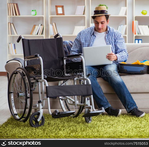 The disabled man booking travel online using laptop computer. Disabled man booking travel online using laptop computer