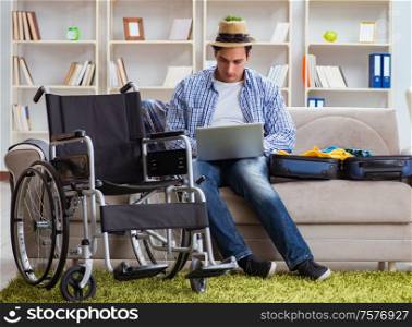 The disabled man booking travel online using laptop computer. Disabled man booking travel online using laptop computer