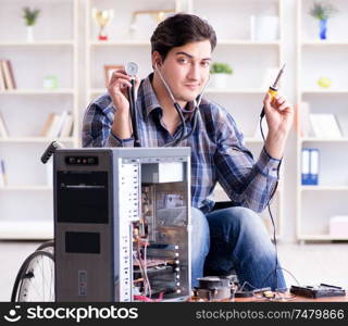 The disabled man on wheelchair repairing computer. Disabled man on wheelchair repairing computer