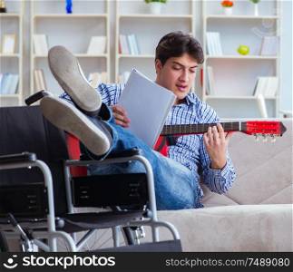 The disabled man playing guitar at home. Disabled man playing guitar at home