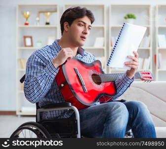 The disabled man playing guitar at home. Disabled man playing guitar at home