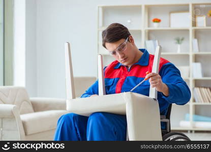 The disabled man repairing chair in workshop. Disabled man repairing chair in workshop