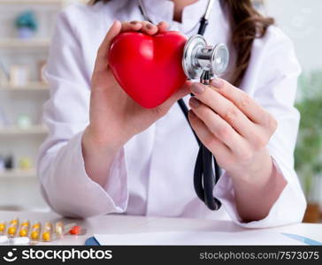 The doctor cardiologist with red heart in the hospital. Doctor cardiologist with red heart in the hospital