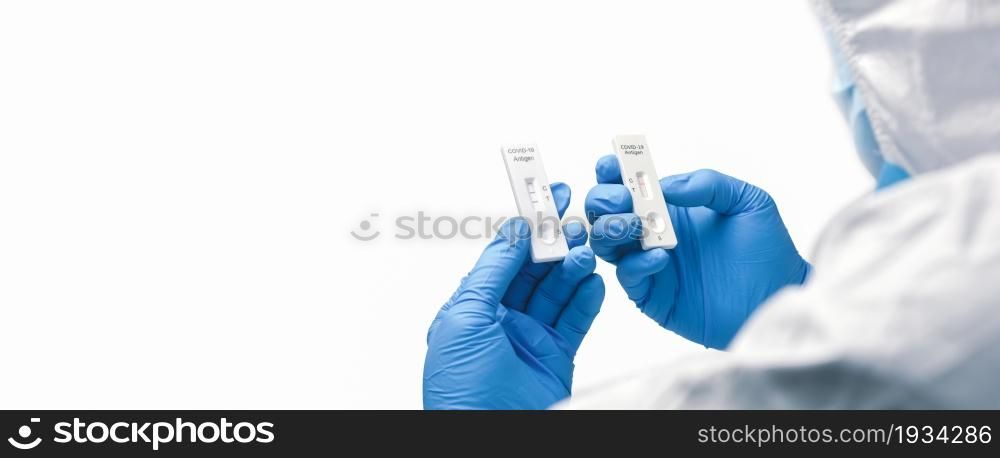 The doctor compares tape from a rapid antigen test kit for a covid-19 result, horizontal copy space on white background