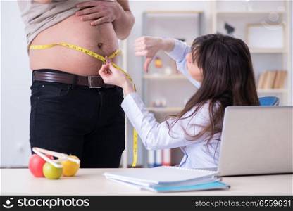 The doctor dietician giving advices to fat overweight patient. Doctor dietician giving advices to fat overweight patient