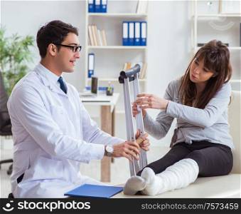 The doctor examining patient with broken leg. Doctor examining patient with broken leg