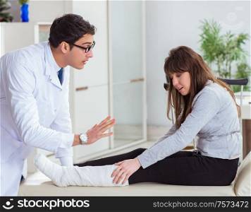 The doctor examining patient with broken leg. Doctor examining patient with broken leg