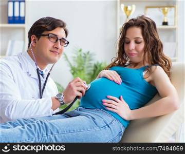 The doctor examining pregnant female patient in hospital. Doctor examining pregnant female patient in hospital