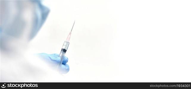 The doctor hand holds a needle syringe for prepare injections, horizontal copy space on white background