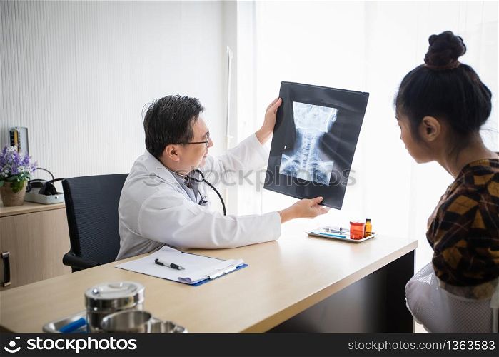The doctor is explaining about the brain X-ray results to a female patient in his office at Hospitals