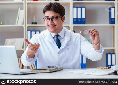 The doctor optician prescribing holding optical glasses . Doctor optician prescribing holding optical glasses
