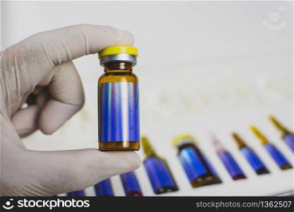 The doctor&rsquo;s hand is picking up the medicine vial bottle from box set,Coronavirus treatment concept,Covid-19.