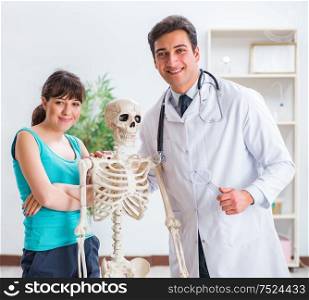 The doctor showing type of injury on skeleton to patient. Doctor showing type of injury on skeleton to patient