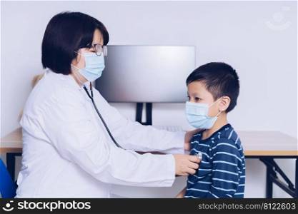 The doctor sits at work, examining a child patient.
