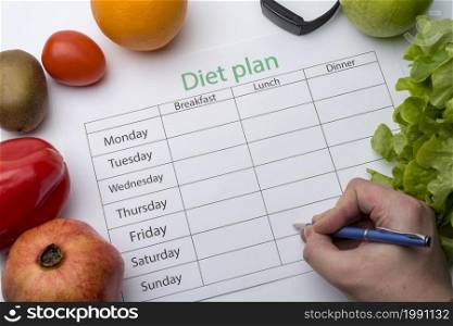 The doctor writes a prescription to the patient, makes a diet plan in the workplace with fresh fruit. Top view, the concept of healthy eating.. The doctor writes a prescription to the patient, makes a diet plan in the workplace with fresh fruit.