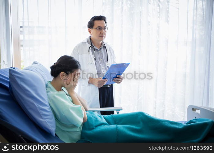 The doctors are asking and explaining about the illness to a female patient lying in bed at a hospital.