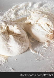 The dough is lying on a white table with flour.. Dough on a white table with flour.