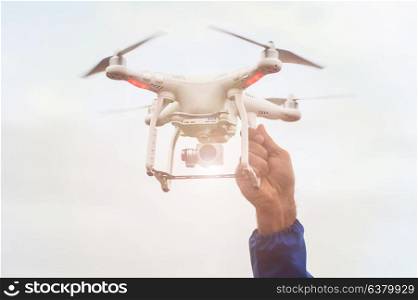 The drone copter with digital camera. The flying drone copter with digital camera and human hand