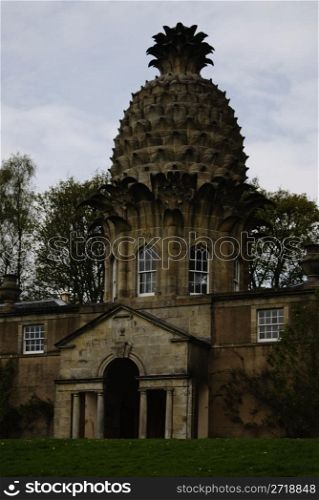 The Dunmore Pineapple is a remarkable folly situated in Dunmore Park, approximately one kilometre northwest of Airth in the Falkirk council area, Scotland. One of the architectural wonders of Scotland, the building was built in the grounds of Dunmore House as a garden retreat and hothouse in 1761 by John Murray, 4th Earl of Dunmore. After the discovery of pineapples by Christopher Columbus on the Caribbean island of Guadeloupe in 1493, the pineapple became a rare delicacy in Europe, and was symbolic of power, wealth, and hospitality. The pineapple was adopted as a motif by architects, artisans and craftsmen, being sculpted into gateposts, railings, weather vanes and door lintels. The Dunmore Pineapple is perhaps the most spectacular architectural use of the motif.