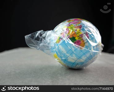 The earth in plastic bag, Global warming due to pollution by plastic debris. The concept of Earth Day.