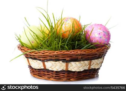 the easter eggs on fresh green grass in basket isolated on white background