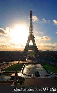 The Eiffel Tower in Paris, France in the morning as the sun rises behind. Lens fare visible.