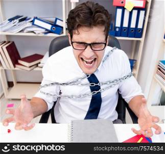 The employee attached and chained to his desk with chain. Employee attached and chained to his desk with chain